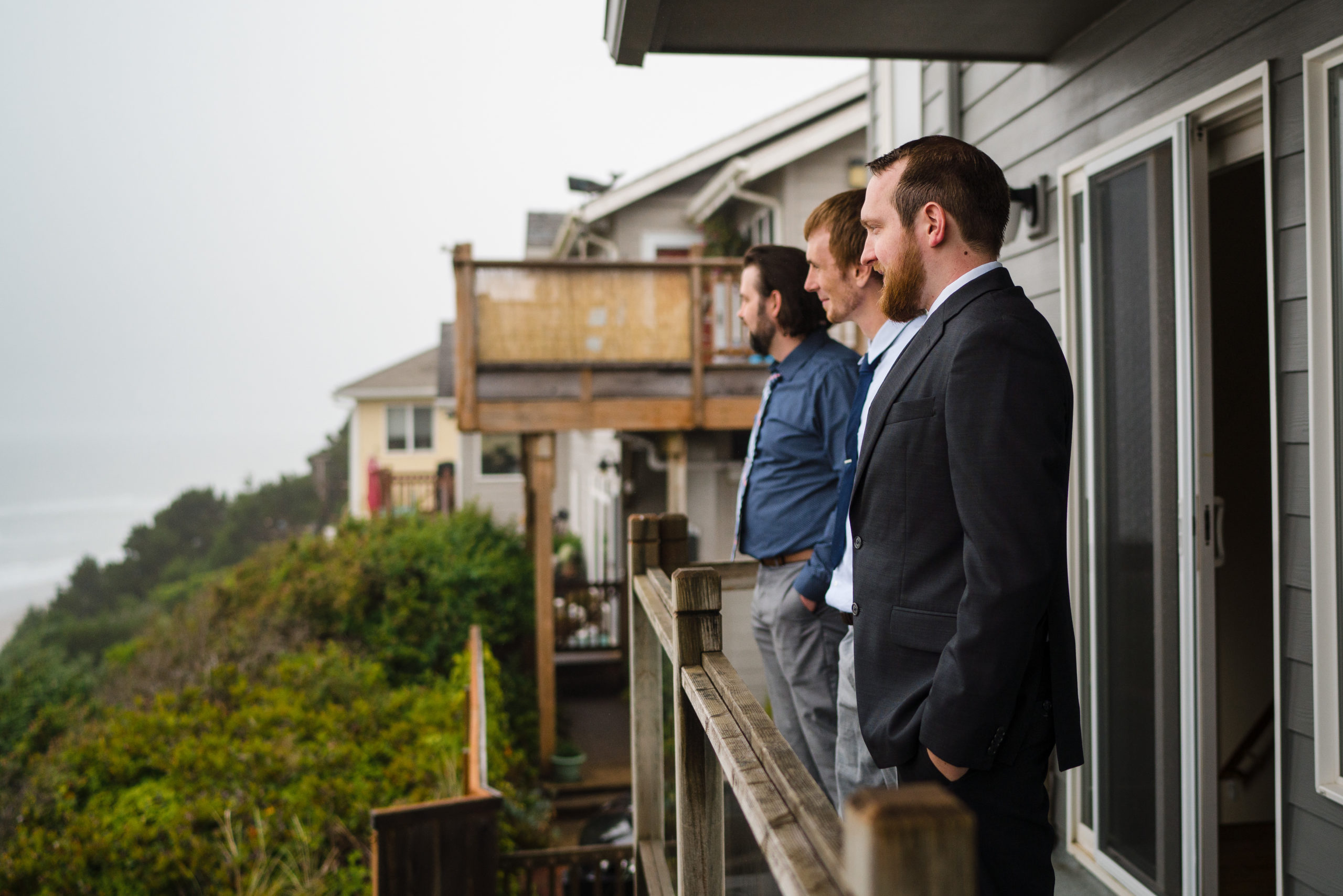 Groom hangs out on the balcony with his friends before heading to the Oregon Coast and Cape Kiwanda for his elopement