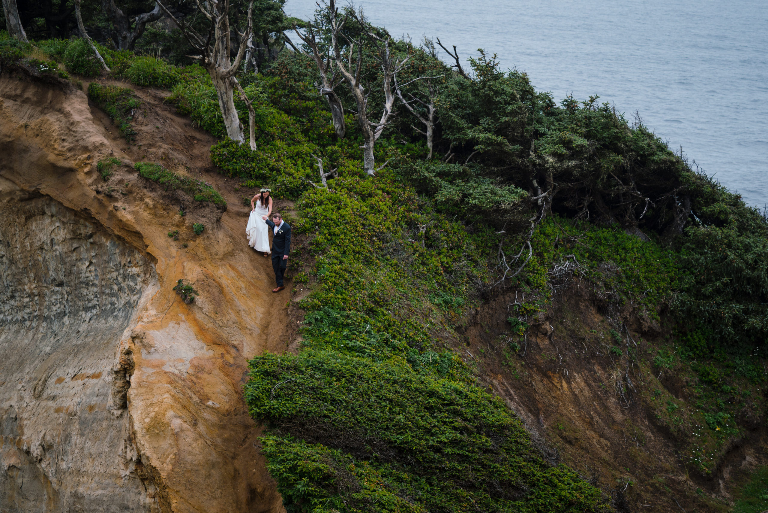 couple hiking up cape kiwanda for their elopement portraits